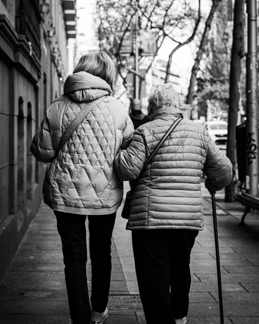 A carer supporting an older person on a walk